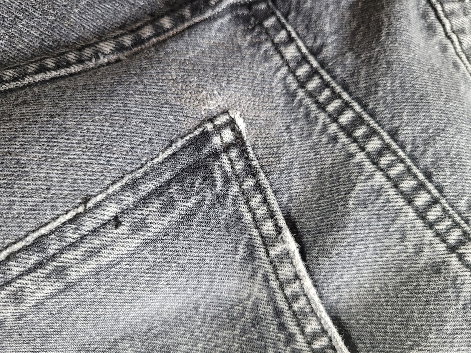 Nahaufnahme einer Jeans-Reparatur mit sauberer Steppnaht