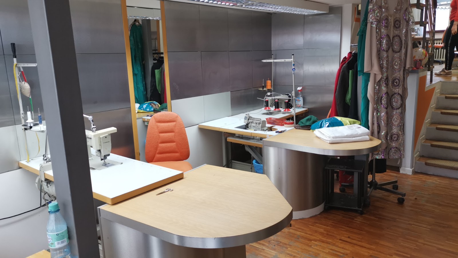 Werkstatt mit Industrie-Nähmaschinen und Abendkleidern